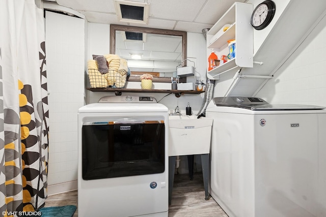 laundry area featuring washer and dryer and light hardwood / wood-style flooring