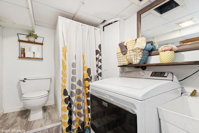 washroom with washer / clothes dryer, wood-type flooring, and sink