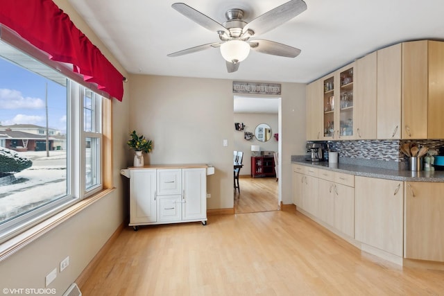 kitchen with light brown cabinetry, ceiling fan, light hardwood / wood-style floors, and tasteful backsplash