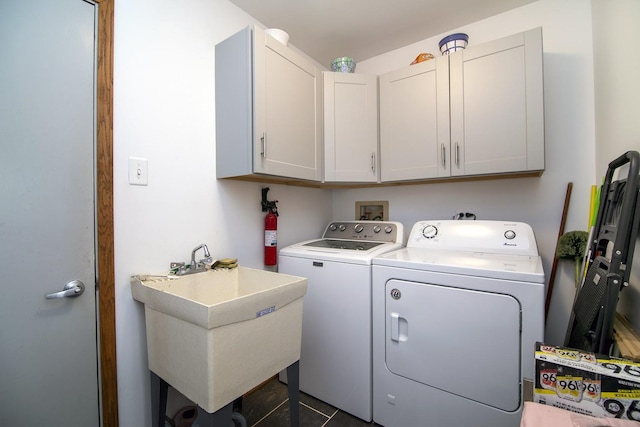 washroom featuring cabinets, sink, and independent washer and dryer