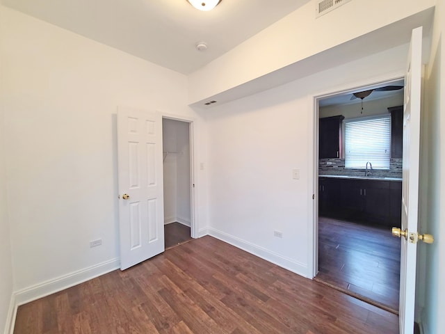 spare room with dark wood-type flooring and sink