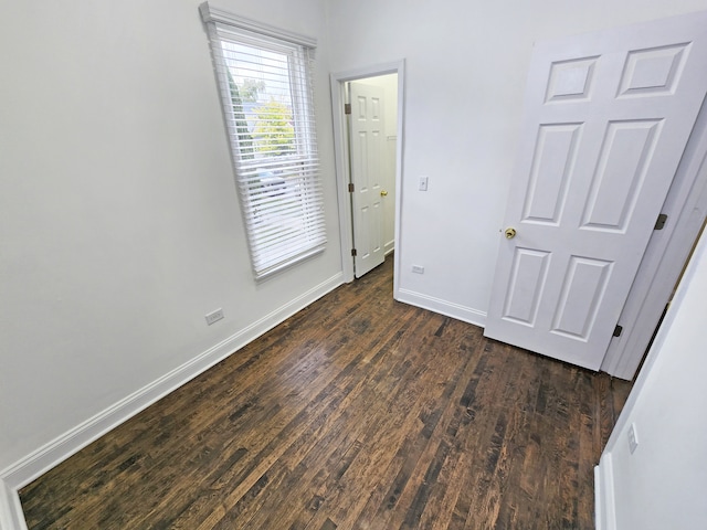 unfurnished bedroom with dark hardwood / wood-style flooring