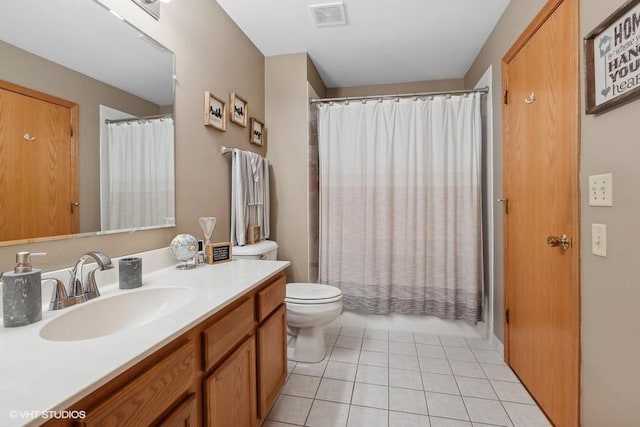 bathroom featuring toilet, tile patterned flooring, vanity, and curtained shower