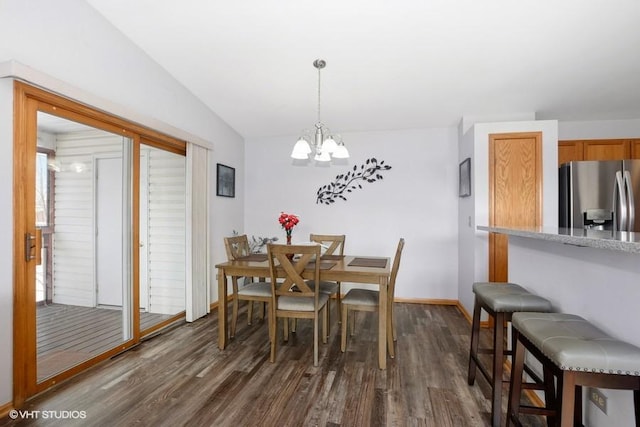 dining space featuring lofted ceiling, dark wood-type flooring, and a chandelier