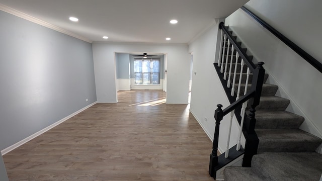 stairs with hardwood / wood-style flooring and crown molding