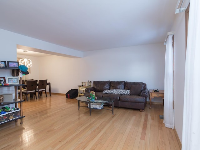 living room featuring a notable chandelier and light hardwood / wood-style floors