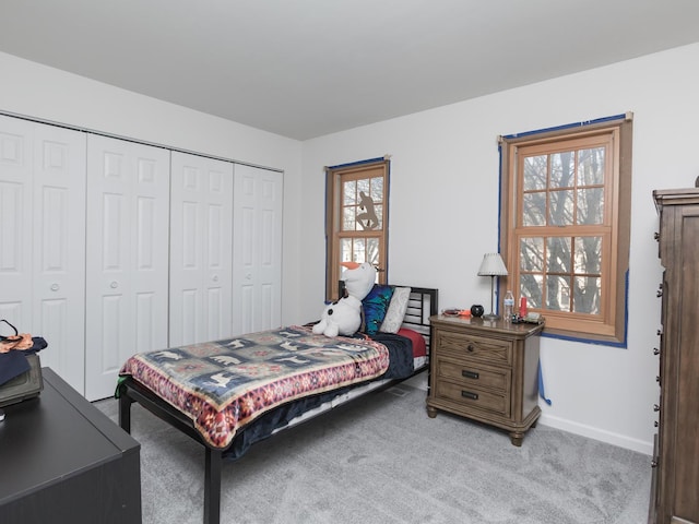 bedroom featuring light colored carpet, a closet, and multiple windows