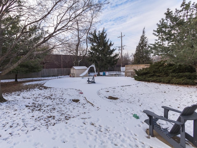 yard covered in snow featuring a storage unit