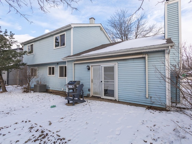 snow covered rear of property with cooling unit