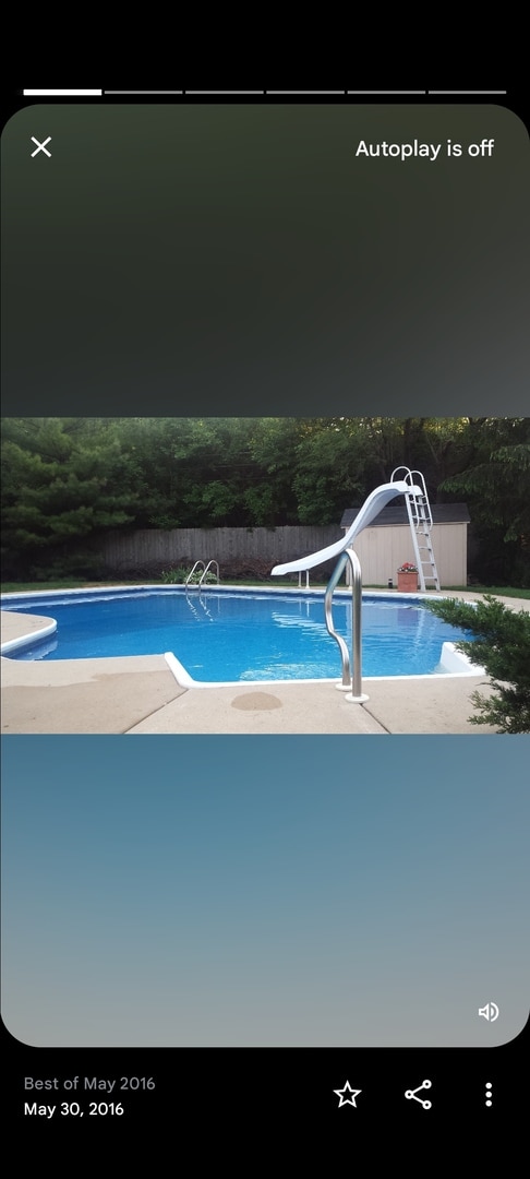 view of swimming pool with a water slide and a diving board