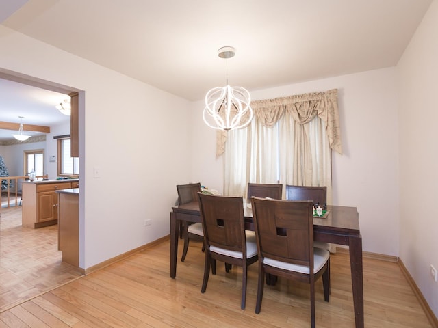 dining space featuring an inviting chandelier and light hardwood / wood-style flooring