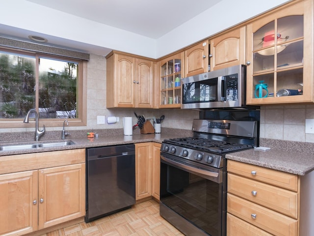 kitchen featuring stainless steel appliances, stone counters, tasteful backsplash, and sink