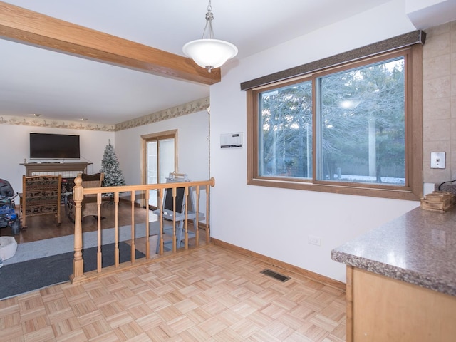 dining area featuring light parquet flooring and beam ceiling