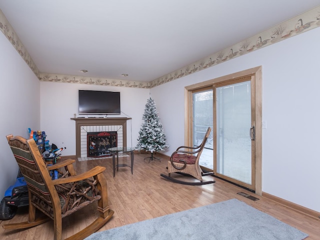 sitting room featuring light wood-type flooring and a fireplace