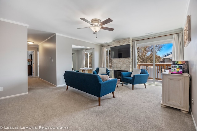 living room with ornamental molding, ceiling fan, light colored carpet, and a fireplace