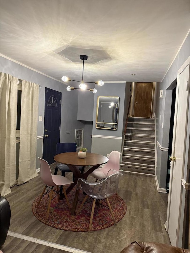 dining area featuring dark wood-type flooring and ornamental molding