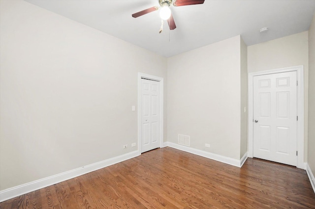 empty room with dark wood-type flooring and ceiling fan