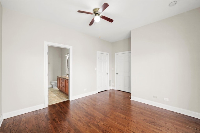 unfurnished bedroom with ceiling fan, light wood-type flooring, and ensuite bath