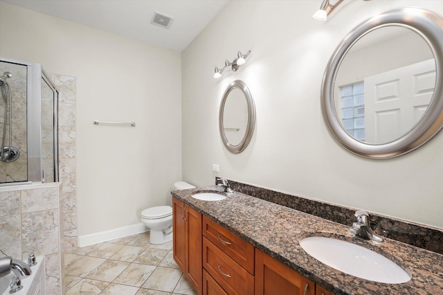 bathroom with vanity, toilet, and a tile shower