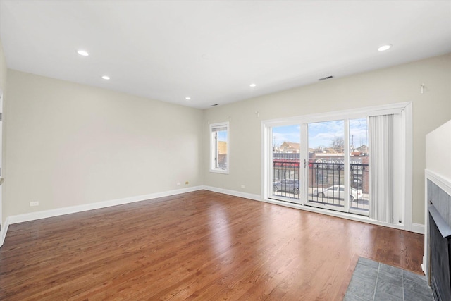 unfurnished living room featuring hardwood / wood-style flooring and a tile fireplace