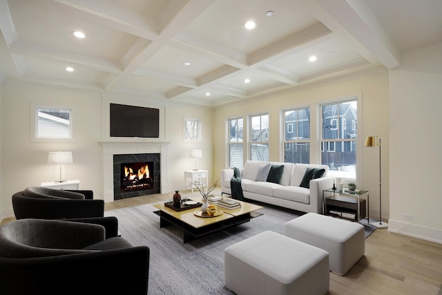 living room with a wealth of natural light, beam ceiling, coffered ceiling, and light wood-style flooring