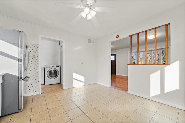 empty room with ceiling fan, washer / clothes dryer, and light tile patterned floors