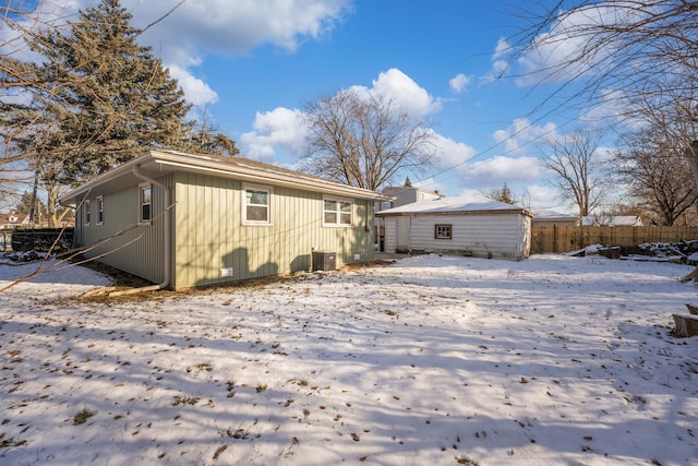 snow covered back of property with central AC unit