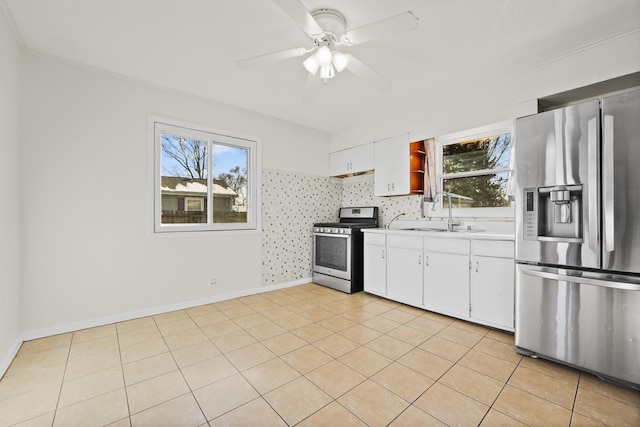 kitchen featuring appliances with stainless steel finishes, light tile patterned floors, ceiling fan, sink, and white cabinetry