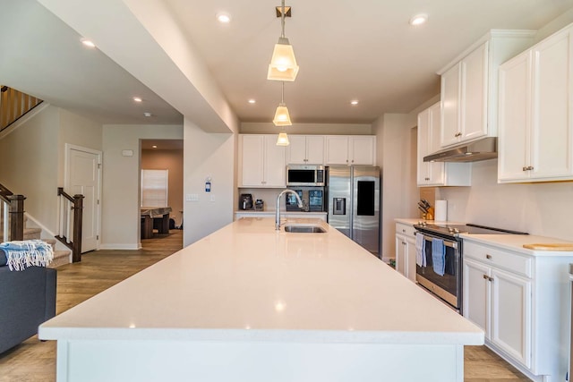 kitchen featuring pendant lighting, a large island, white cabinetry, appliances with stainless steel finishes, and sink