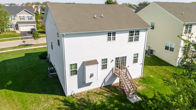 back of property featuring central AC unit and a lawn