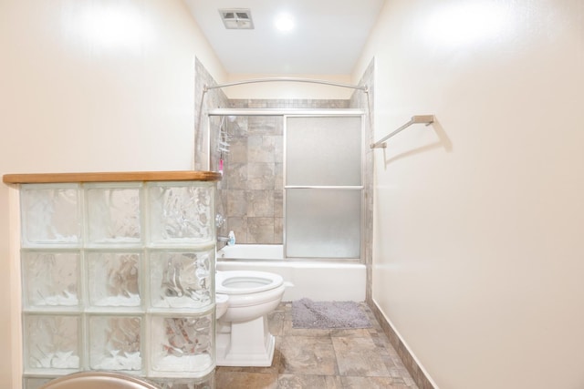 bathroom featuring combined bath / shower with glass door and toilet