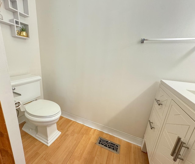 bathroom featuring toilet, vanity, and hardwood / wood-style floors