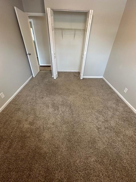 unfurnished bedroom with a closet and carpet flooring