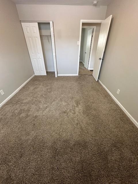 unfurnished bedroom with a closet and carpet