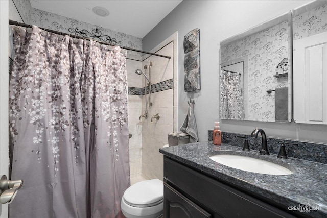 bathroom featuring toilet, vanity, and curtained shower