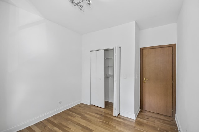 unfurnished bedroom with a closet and light hardwood / wood-style flooring