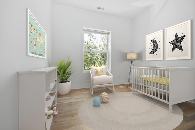 bedroom featuring light hardwood / wood-style floors and a crib