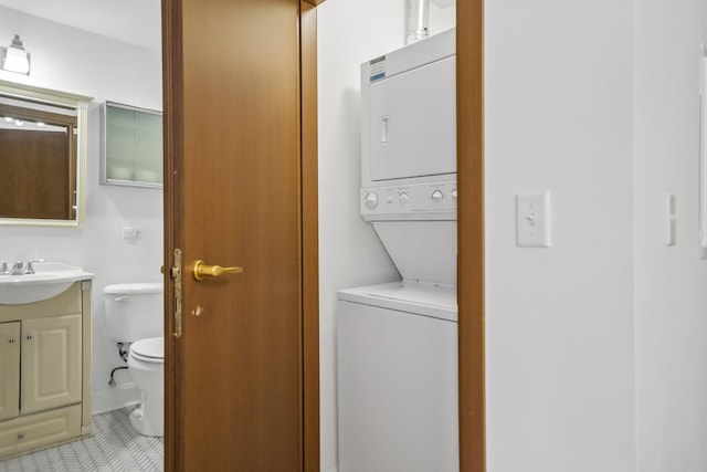 clothes washing area featuring sink, stacked washing maching and dryer, and light tile patterned flooring