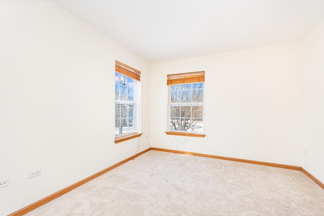 unfurnished room featuring light carpet