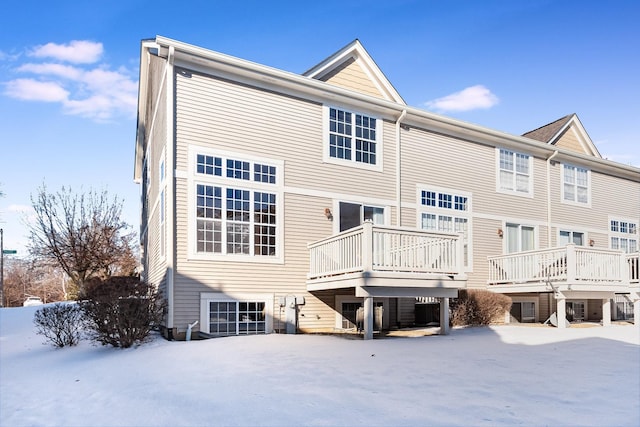 snow covered house with a deck