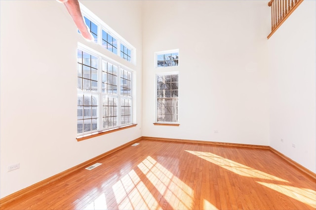 empty room with a high ceiling and hardwood / wood-style floors