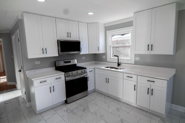 kitchen featuring sink, white cabinets, light stone counters, and appliances with stainless steel finishes