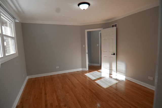 unfurnished room featuring crown molding and light hardwood / wood-style flooring