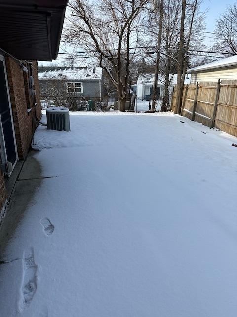 yard covered in snow with central air condition unit