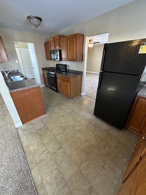 kitchen with ceiling fan, black appliances, and sink