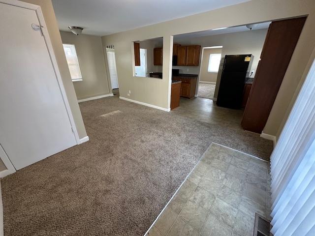 unfurnished living room featuring light colored carpet