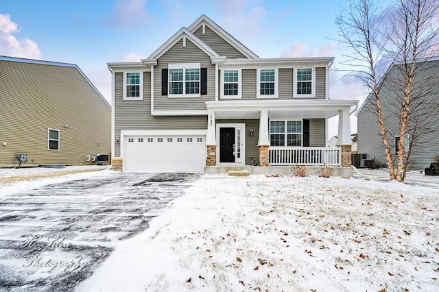 craftsman-style home featuring a garage, covered porch, and central air condition unit