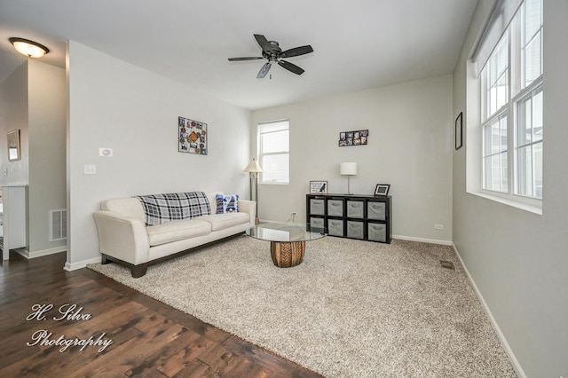 living room with ceiling fan and dark wood-type flooring