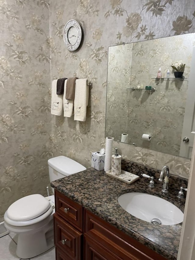 bathroom featuring vanity, tile patterned floors, and toilet