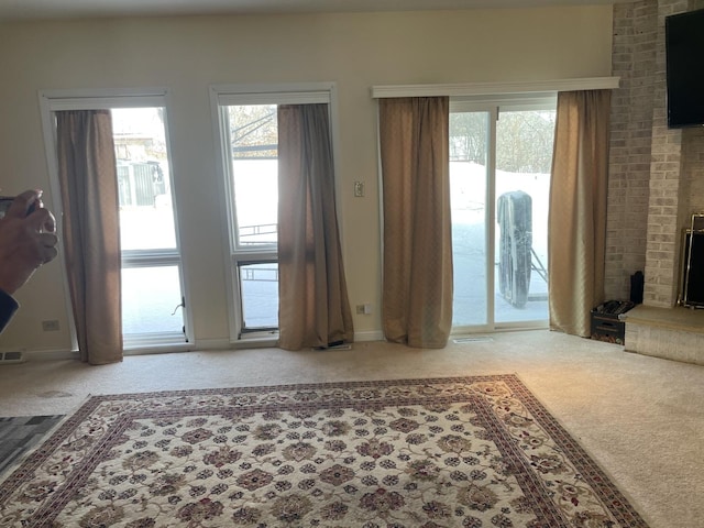 living room with plenty of natural light, carpet flooring, and a fireplace